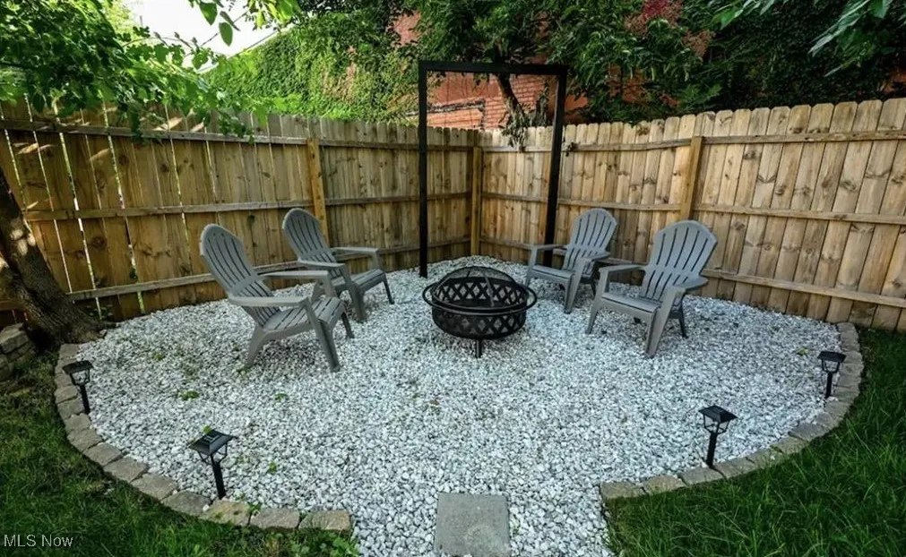 Fenced backyard with an outdoor fire pit and a patio​​‌​​​​‌​​‌‌​‌‌​​​‌‌​‌​‌​‌​​​‌​​ area