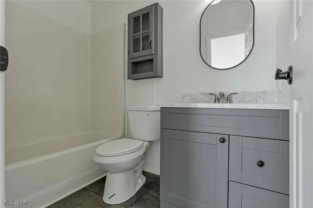 Bathroom featuring vanity, bathing tub / shower combination, and tile patterned floors