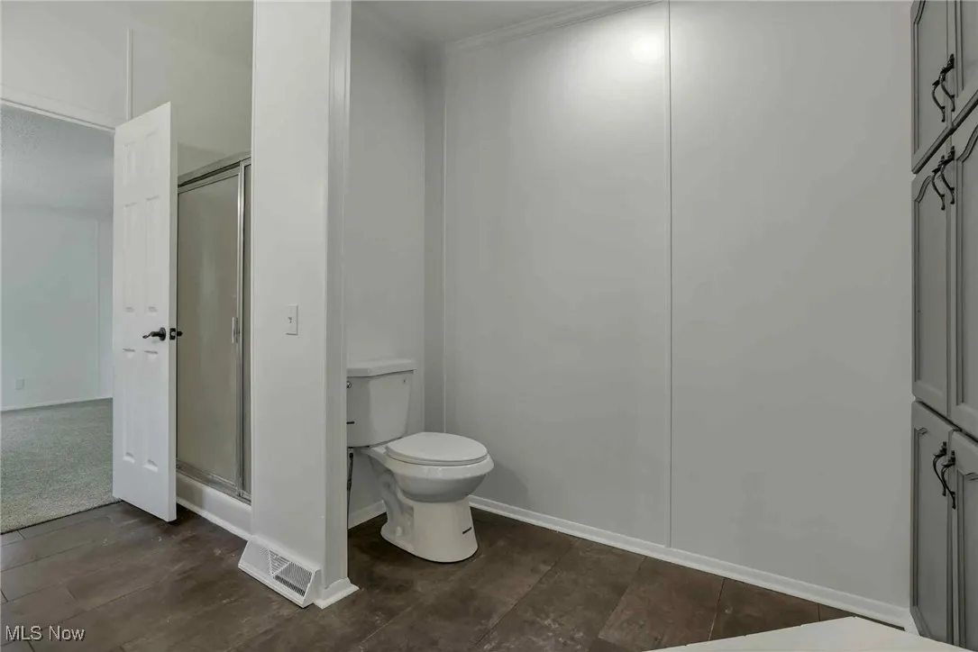 Full bathroom with toilet and a shower stall