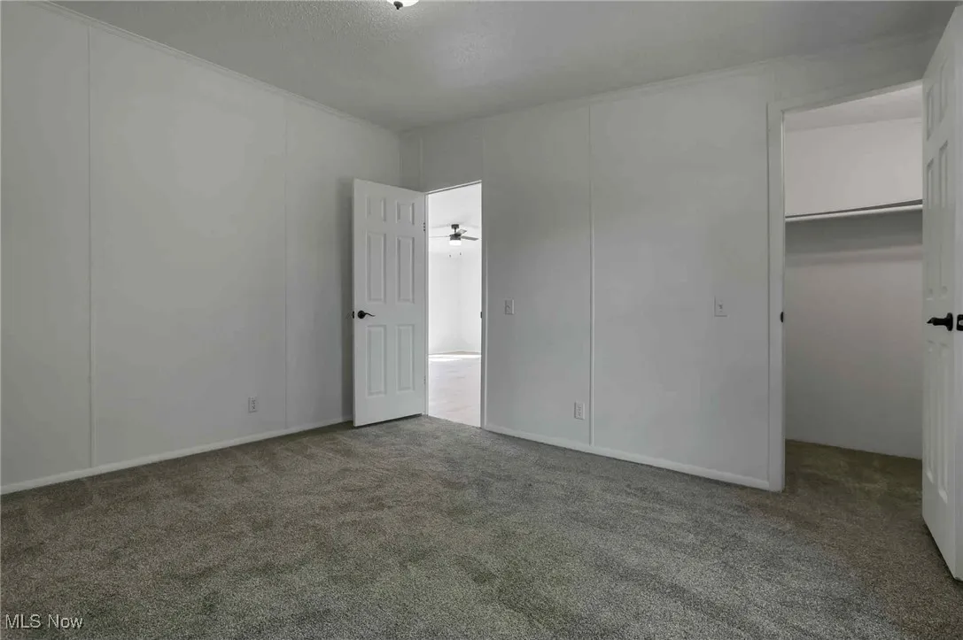 Unfurnished bedroom with a spacious closet and carpet flooring
