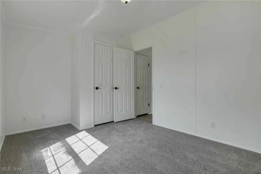 Unfurnished bedroom featuring carpet flooring and baseboards