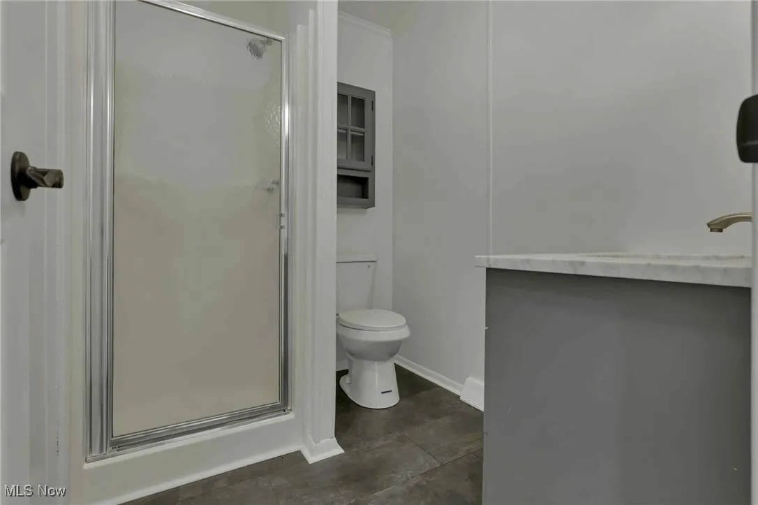 Bathroom featuring a stall shower and toilet