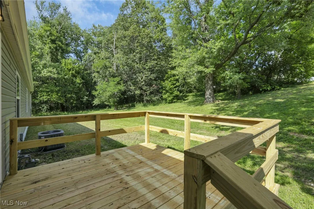 Wooden terrace featuring a yard