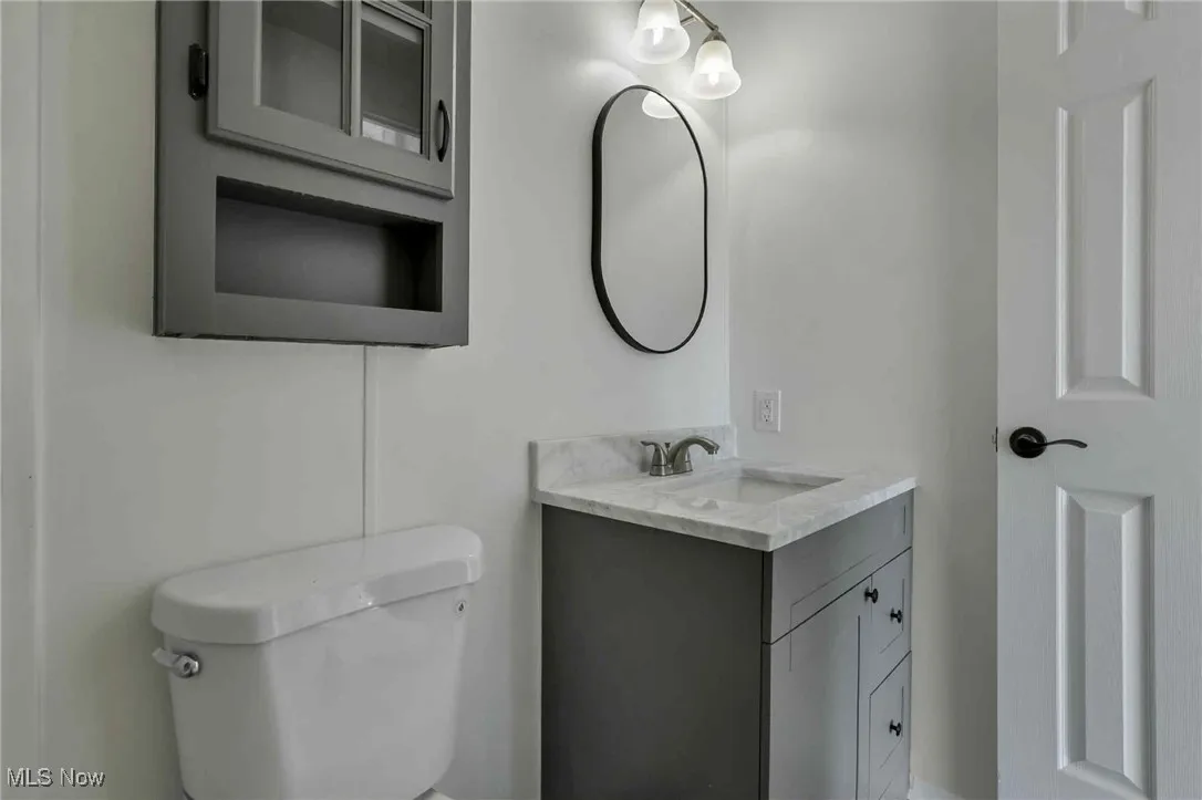 Half bathroom featuring toilet and vanity