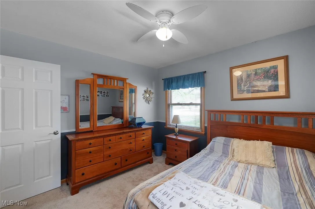 Bedroom with light colored carpet and ceiling fan