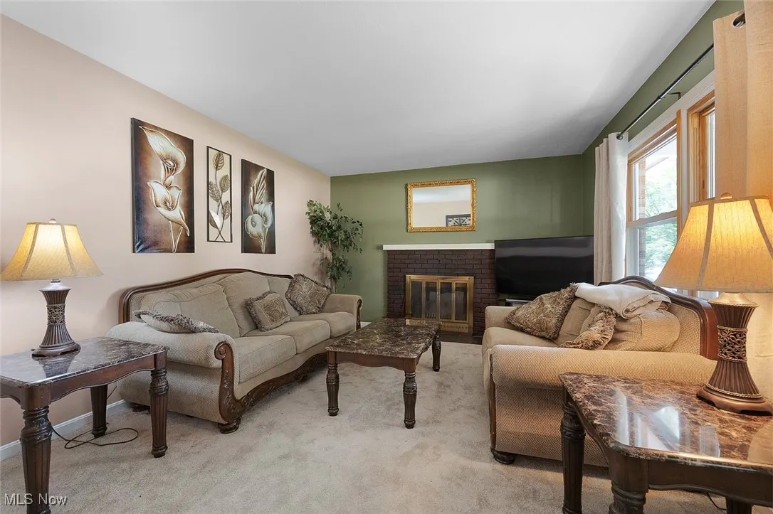Living room featuring light carpet and a fireplace