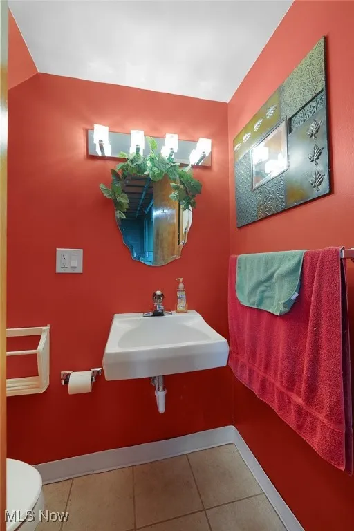 Half bathroom featuring baseboards and tile patterned flooring