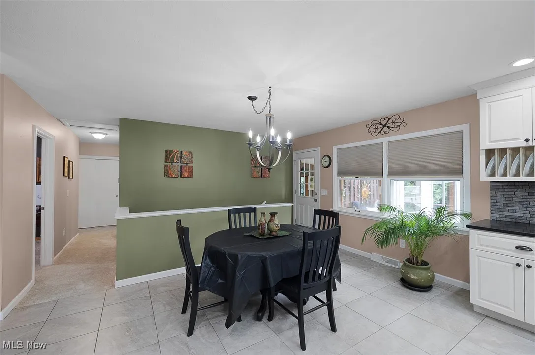 Dining area with a chandelier and light tile patterned floors