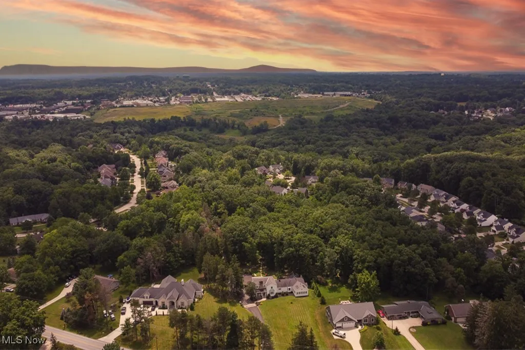 Aerial view of property and surrounding area featuring nearby suburban area