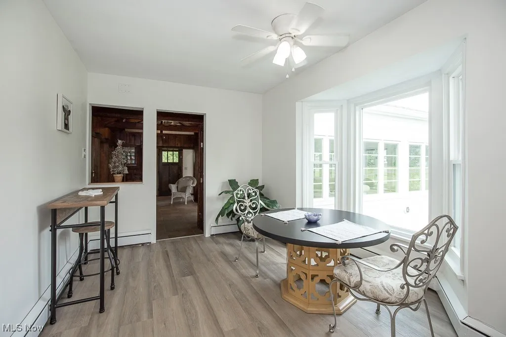 Dining area with healthy amount of natural light, wood finished floors, and a ceiling fan