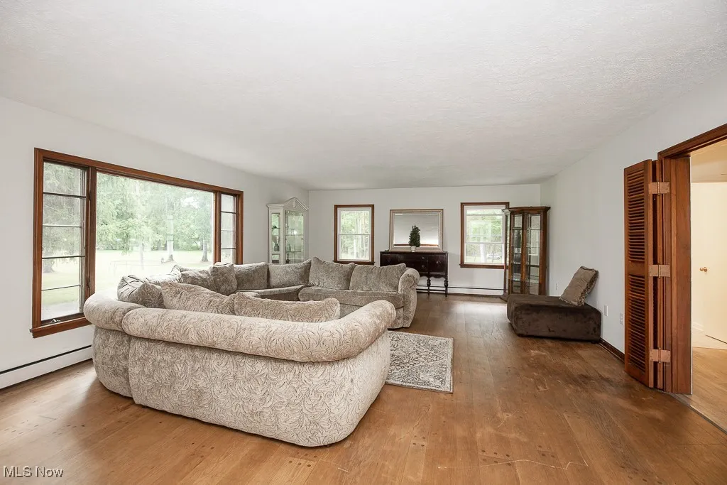 Living area with hardwood / wood-style flooring, a baseboard radiator, and a baseboard heating unit