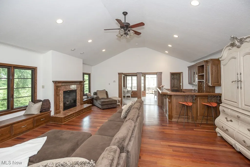Living room with recessed lighting, a ceiling fan, wood finished floors, plenty of natural light, and a premium fireplace