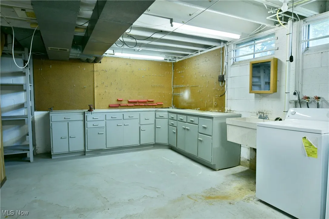 Below grade area with washer / clothes dryer and concrete block wall