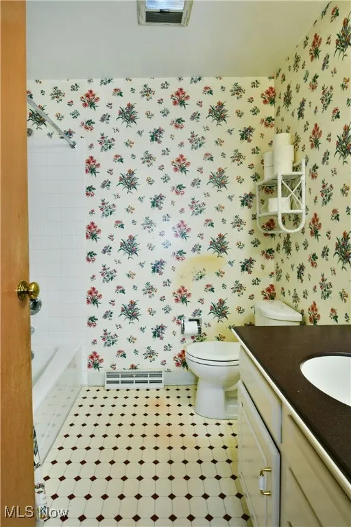 Bathroom with wallpapered walls and vanity