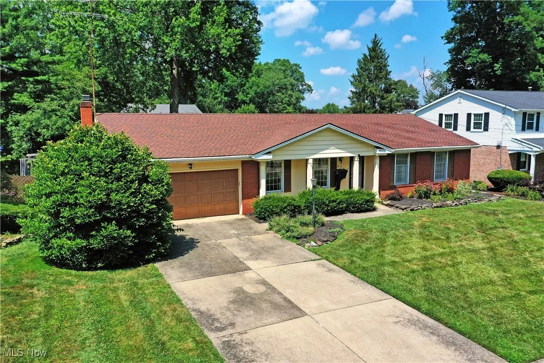 Single story home featuring brick siding, driveway, a front yard, an attached garage, and a​​‌​​​​‌​​‌‌​‌‌​​​‌‌​‌​‌​‌​​​‌​​ chimney