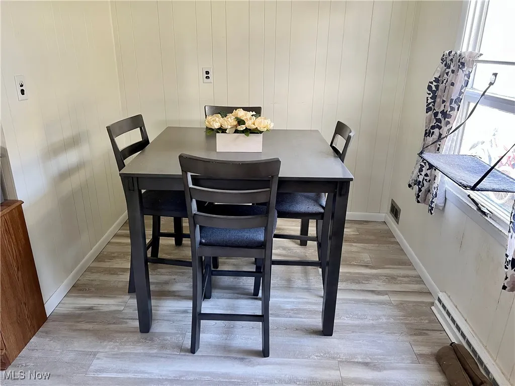 Eat in kitchen area with light wood-type flooring, and large window with natural light