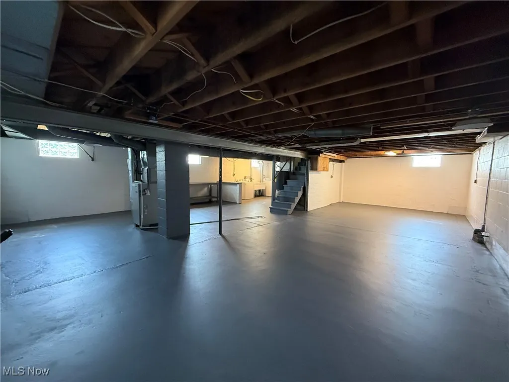 Below grade area featuring stairs and heating unit
