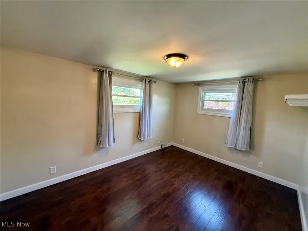 Unfurnished room featuring dark wood finished floors and plenty of natural light
