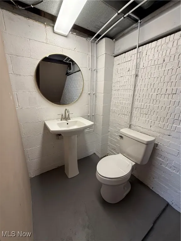Bathroom featuring concrete floors and concrete block wall