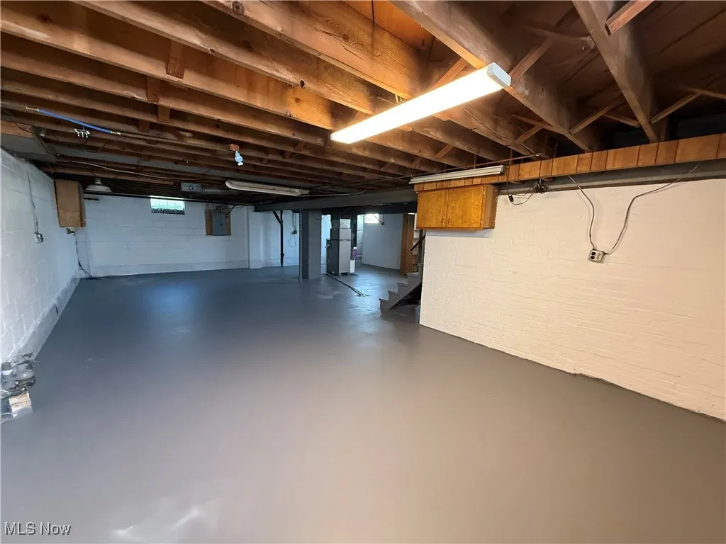Below grade area featuring stairway and electric panel