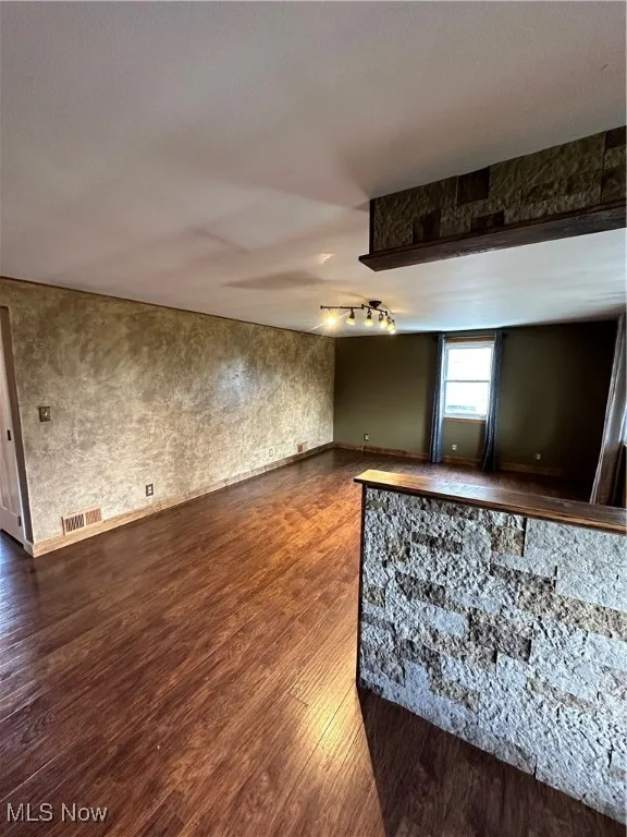 Unfurnished room featuring dark wood-style floors and track lighting