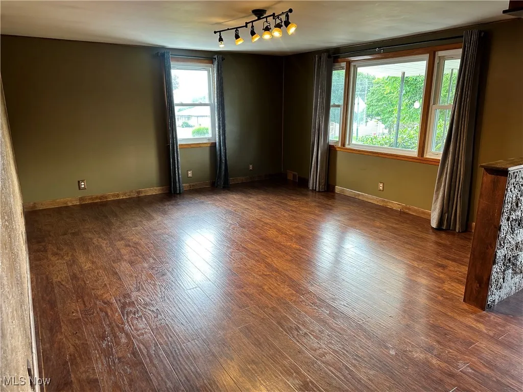 Unfurnished room featuring wood finished floors and track lighting