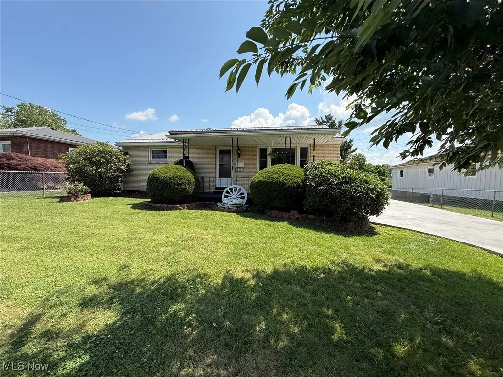 View of front of house featuring brick siding, a porch, and concrete driveway
