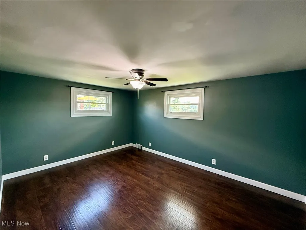 Spare room with a ceiling fan and dark wood-type flooring