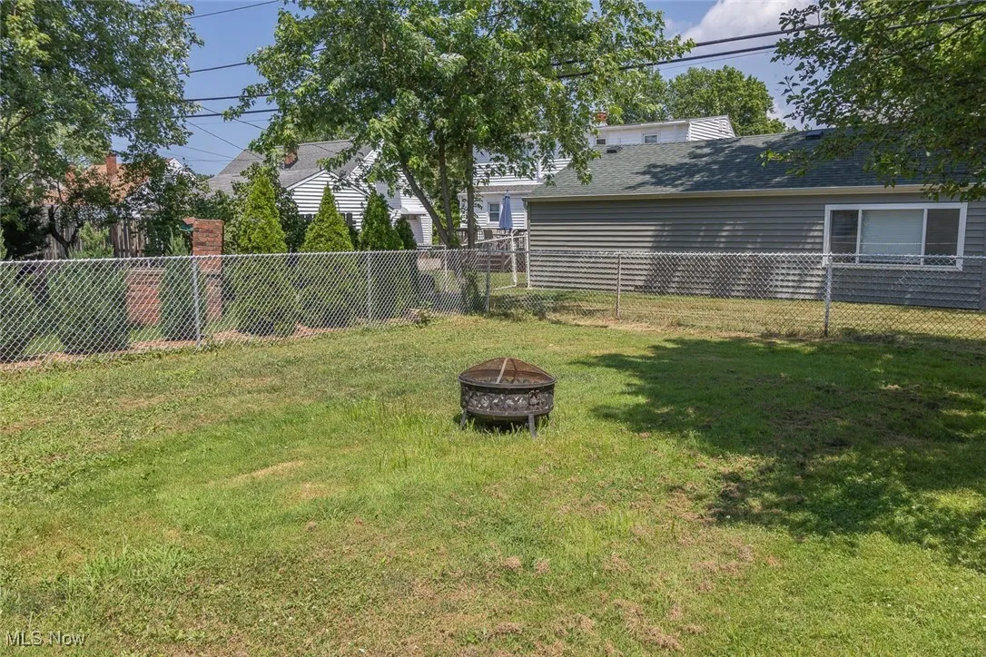 Fenced backyard with a fire pit