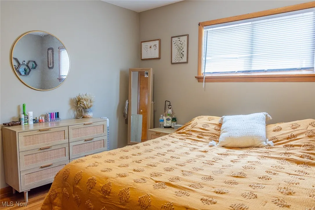 Bedroom one with wood finished floors