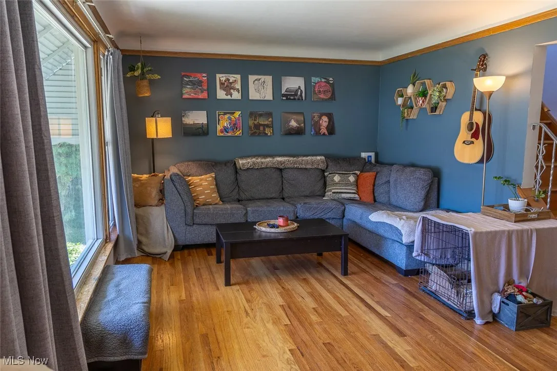 Living room featuring light wood-style floors and ornamental molding