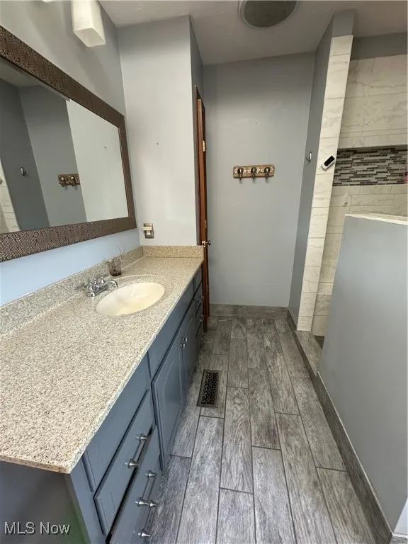 Bathroom with vanity, ceramic tile floors, and a tile shower
