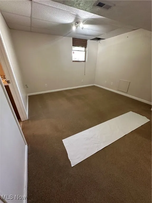 Basement bedroom featuring carpet floors and drop ceilings
