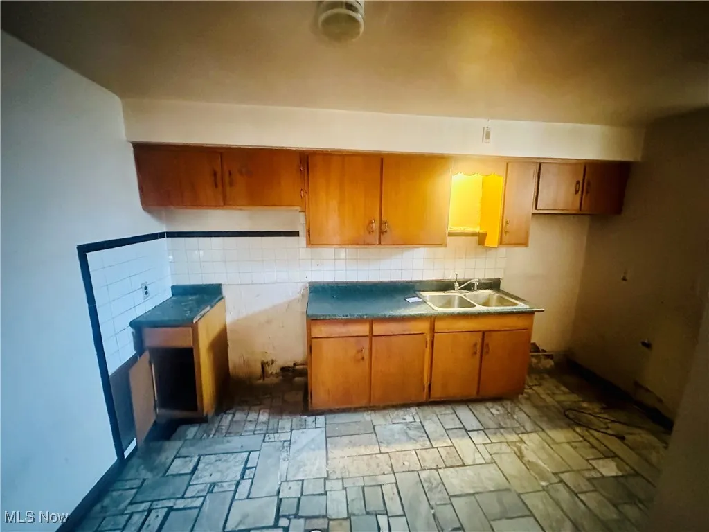 Kitchen featuring tasteful backsplash and sink