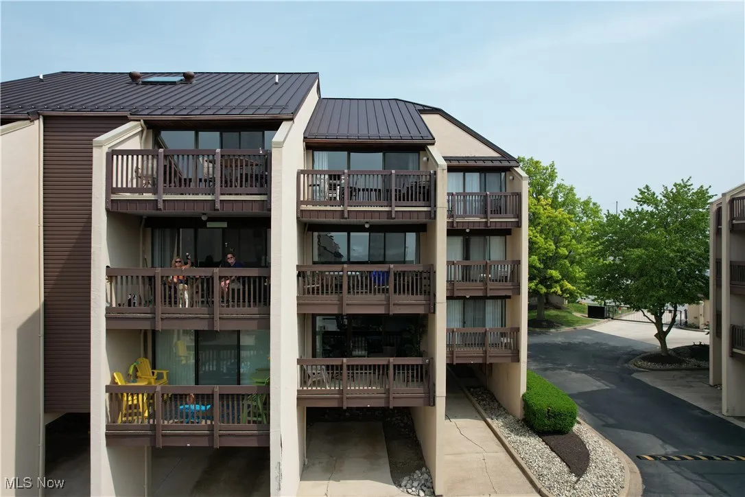 Rear view of house featuring a standing seam roof, a metal roof, and a balcony