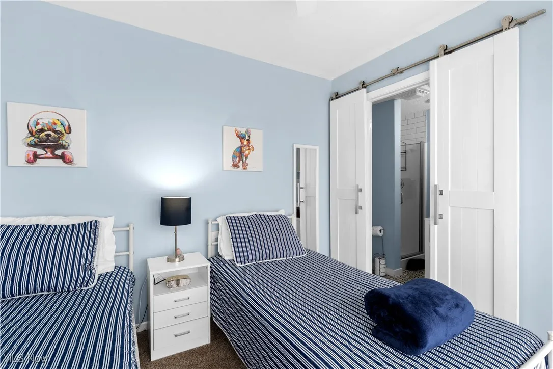 Bedroom featuring dark carpet and a barn door