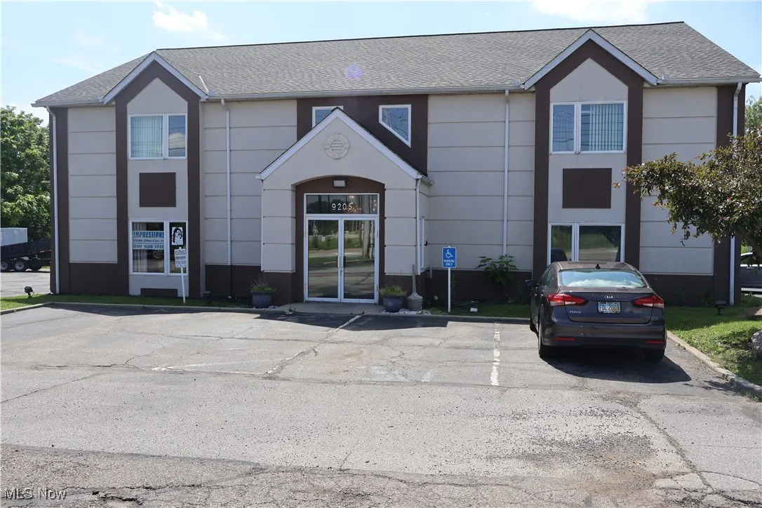 View of property featuring uncovered parking