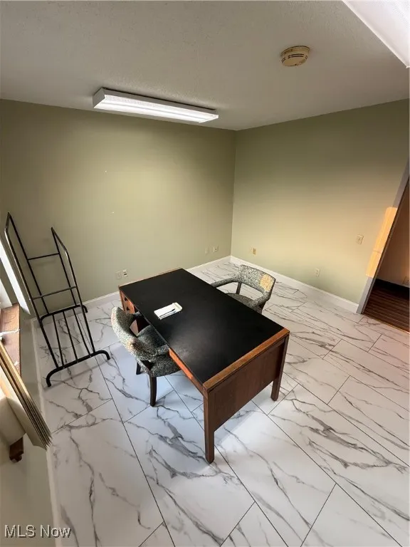 Rec room with marble finish floors and a textured ceiling