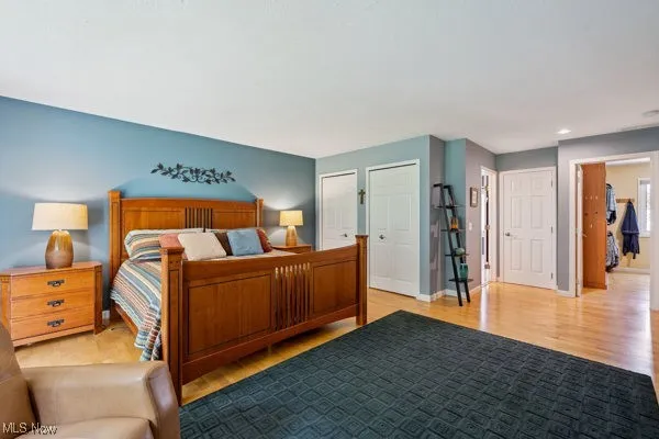 Bedroom featuring light wood-style flooring, multiple closets, and recessed lighting