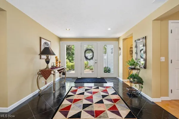 Foyer with baseboards and recessed lighting