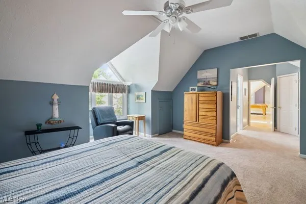 Bedroom with lofted ceiling, carpet floors, and a ceiling fan