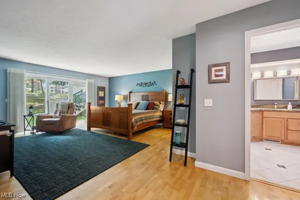 Bedroom featuring light wood-style flooring and ensuite bath