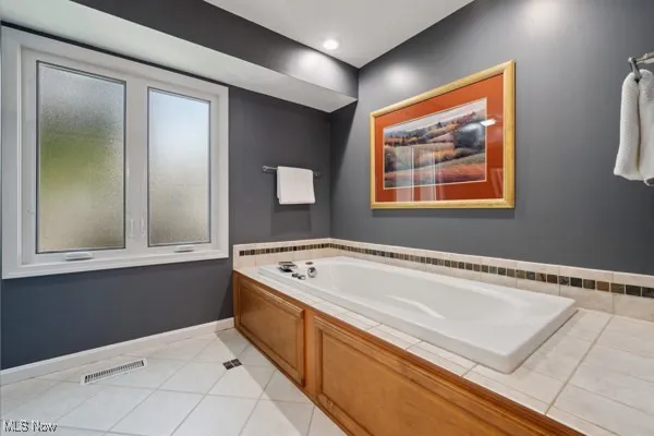 Bathroom with a garden tub and tile patterned floors