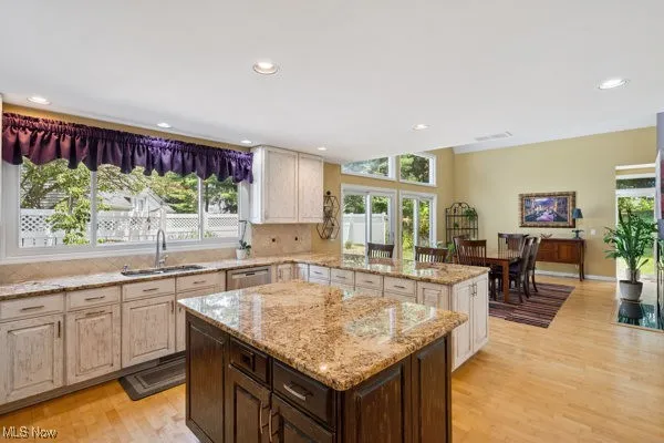 Kitchen featuring light wood-style flooring, plenty of natural light, a kitchen island, and recessed lighting