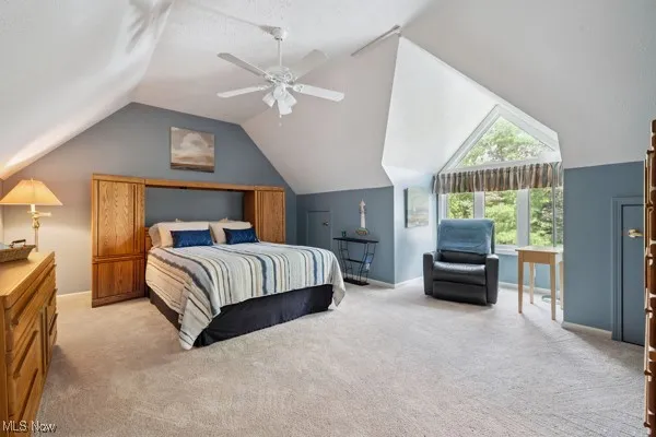 Bedroom with lofted ceiling, carpet flooring, and ceiling fan