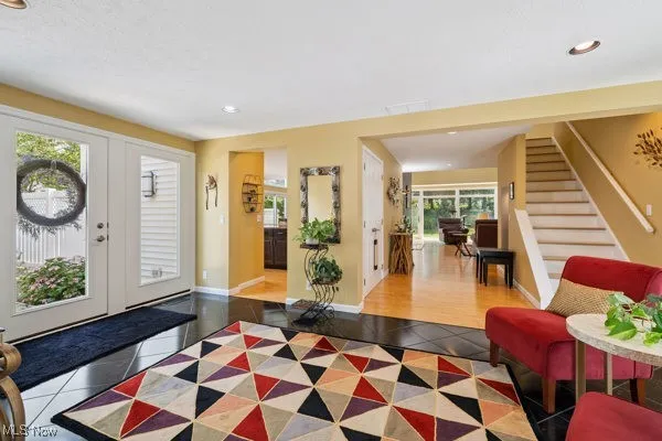 Tiled foyer with recessed lighting, stairway, and french doors