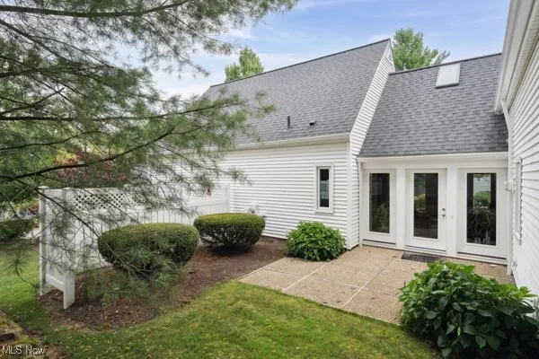 Back of property featuring roof with shingles, a patio, and french doors