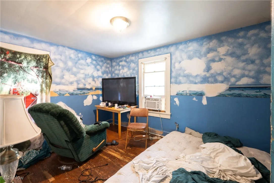 Bedroom featuring wood finished floors, wallpapered walls, and cooling unit