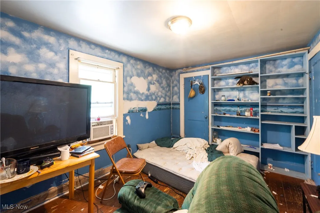 Office space featuring wallpapered walls and wood finished floors