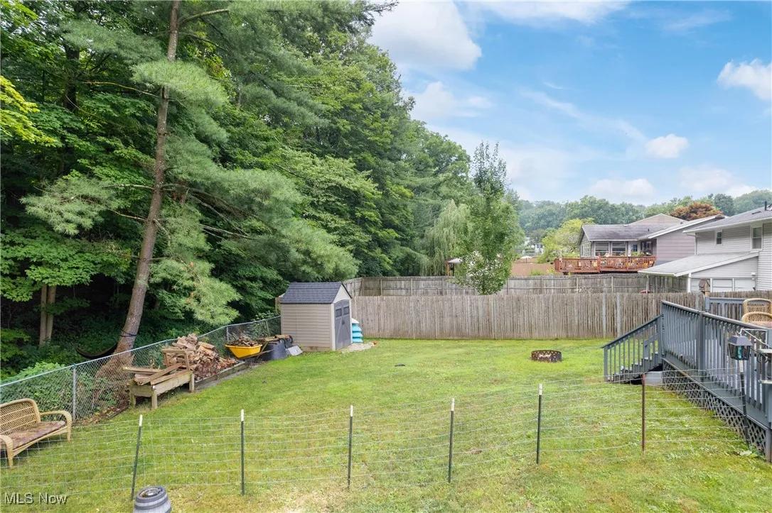 Fenced backyard with a storage shed and a deck